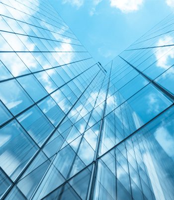 A high rise building against a blue sky with clouds