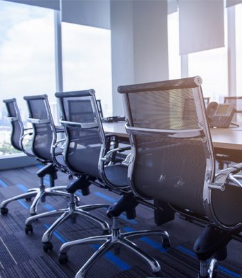 A modern conference room with chairs and a computer screen
