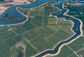 An aerial view of farmland separated by large bodies of water