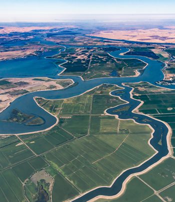 An aerial view of farmland separated by large bodies of water